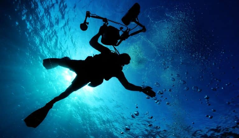 scuba diver holding a camera