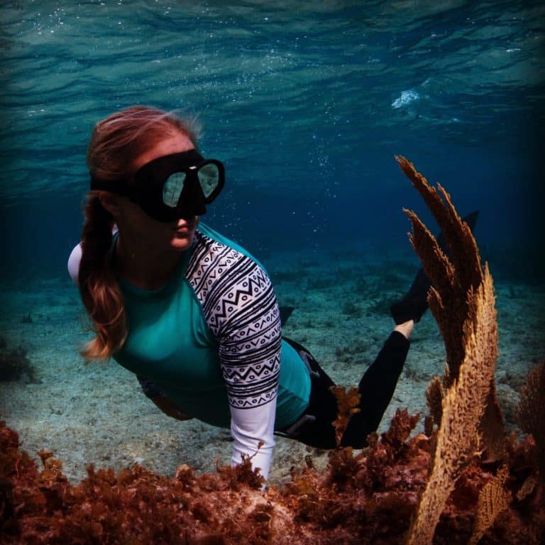 Britney Ouellette freediving with coral underwater