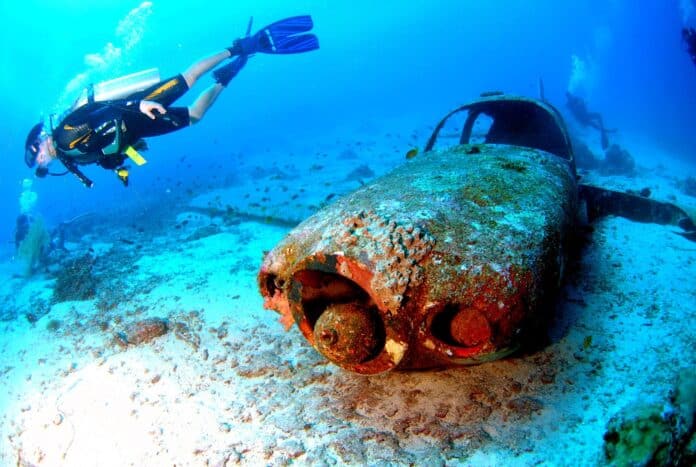 a scuba diver next to a car wreck. We want to know how long does a scuba certification last if you don't dive often.