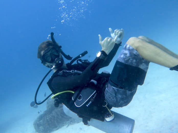 A scuba instructor showing us what scuba diving is underwater.