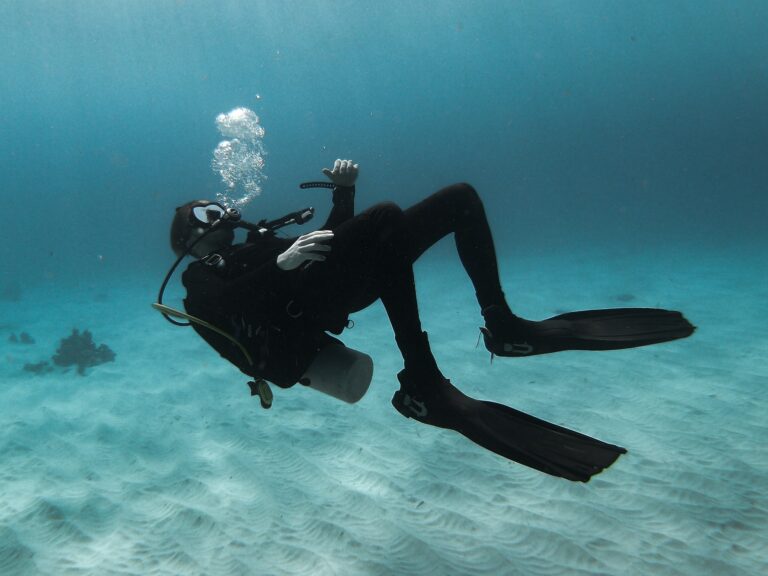 A man wearing a wetsuit is upside down as he contemplates how much does a wetsuit cost?