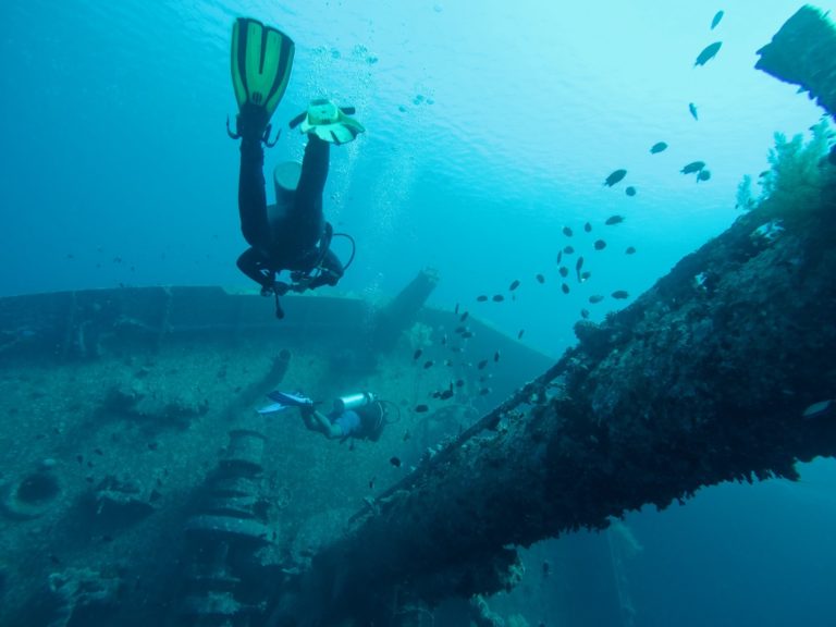 Scuba divers diving on a wreck. It is important to know how to give a good briefing before every dive.