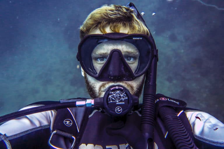 A diver taking a selfie underwater. We want to know mask clearing tips to use underwater.