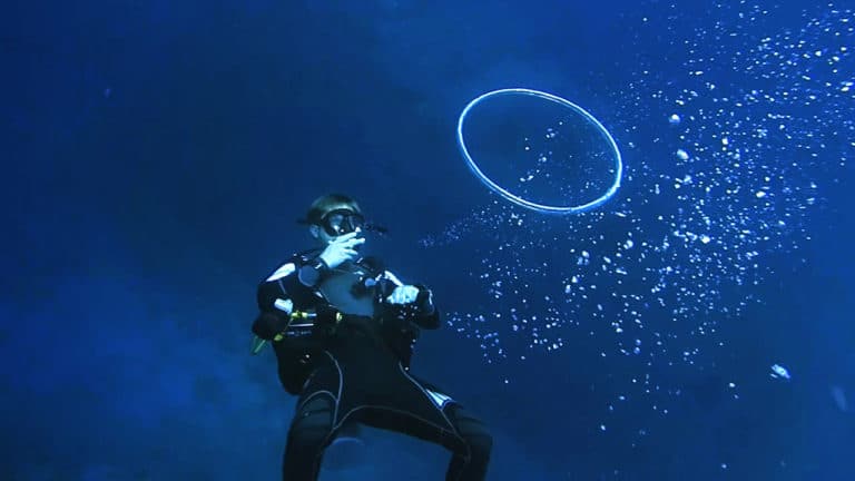 How to make a bubble ring underwater. Scuba diver blowing a bubble ring.