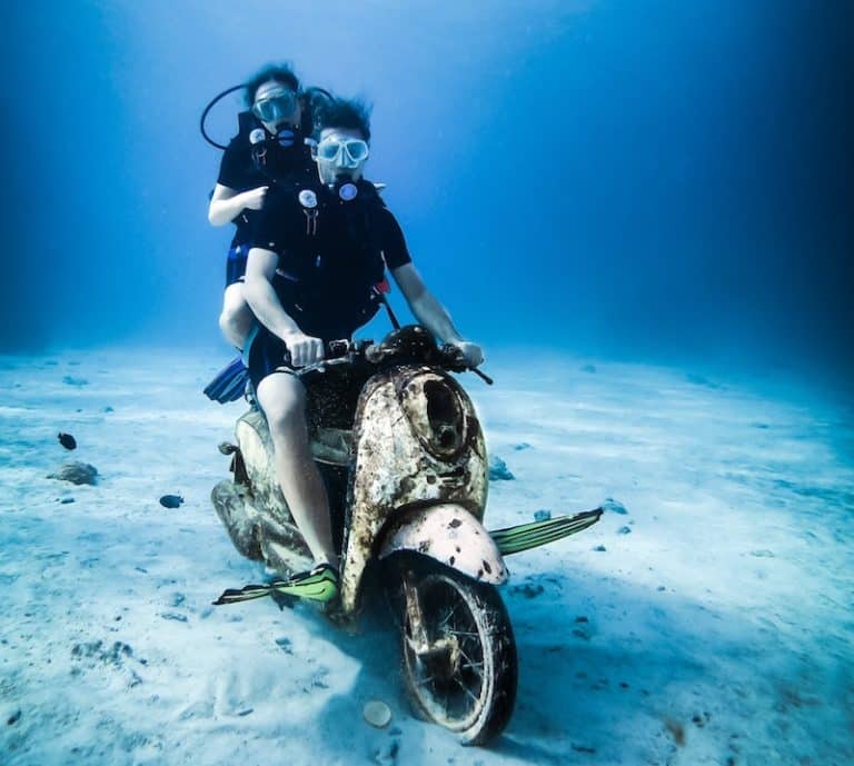 Two scuba divers riding an underwater scooter - funny diving jokes and puns